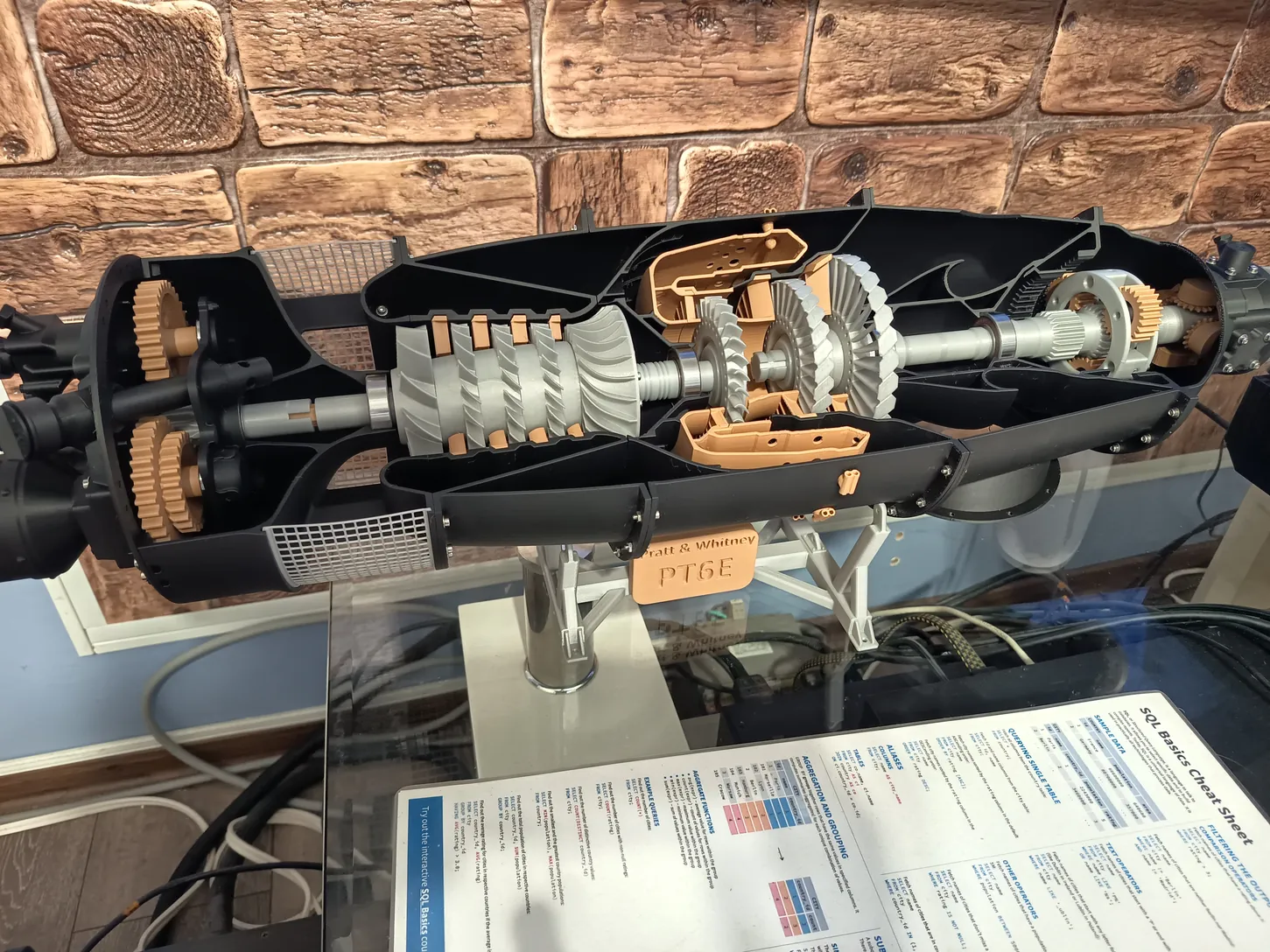Pratt & Whitney PT6E turbólégcsavaros hajtómű metszeti makettje állványon, feltárt fogaskerekekkel és kompresszorfokozatokkal.