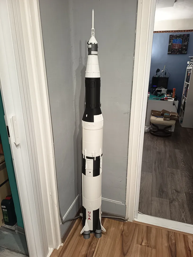 A teljes Saturn V hordozórakéta makettje álló helyzetben, padlótól közel a mennyezetig érő magasságban.